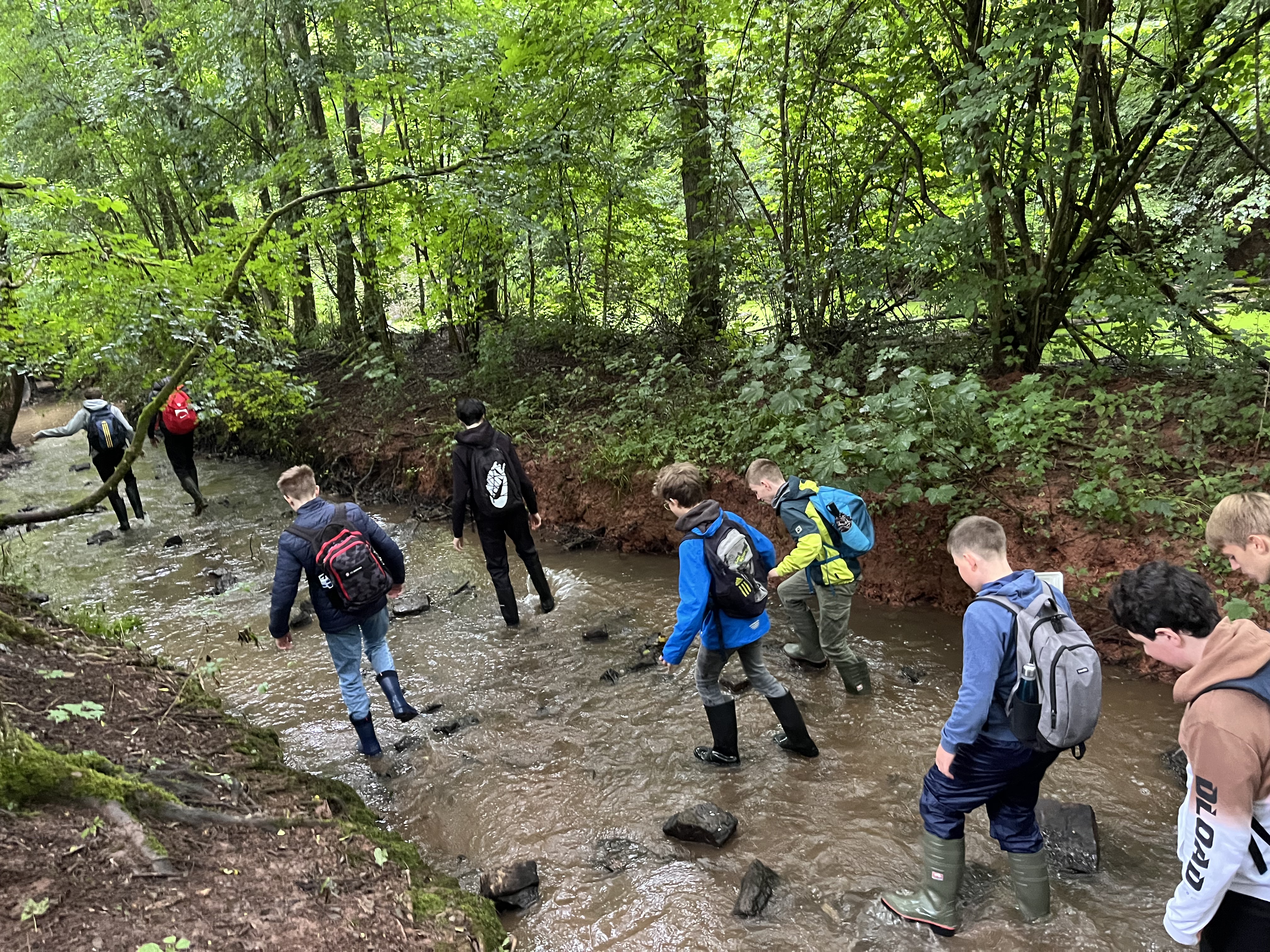 schüler der 8b stiefeln in gummistiefeln durch den konzer bach